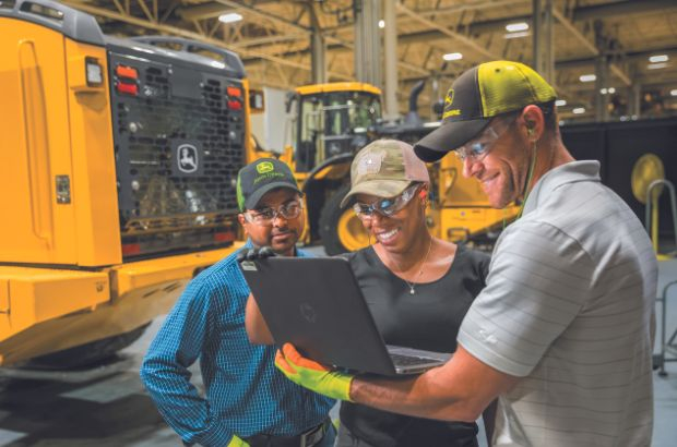 Three John Deere Employees looking at a laptop